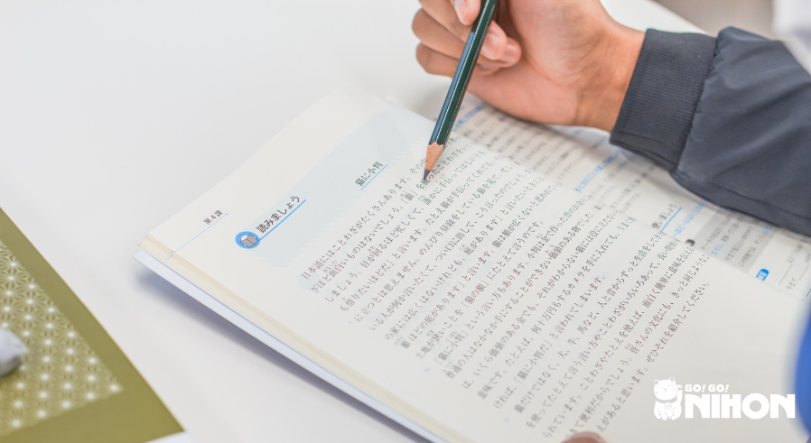 Uno studente che studia da un libro di testo e si prepara per l'esame JLPT