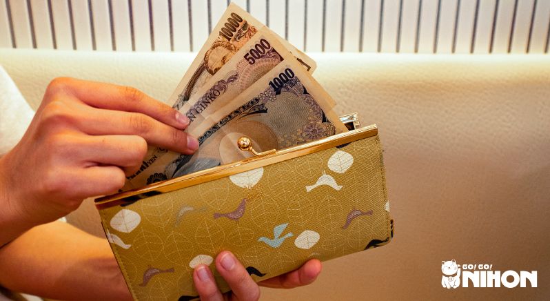 Money being placed inside wallet. Cash over 1 million yen is what not to bring to Japan.
