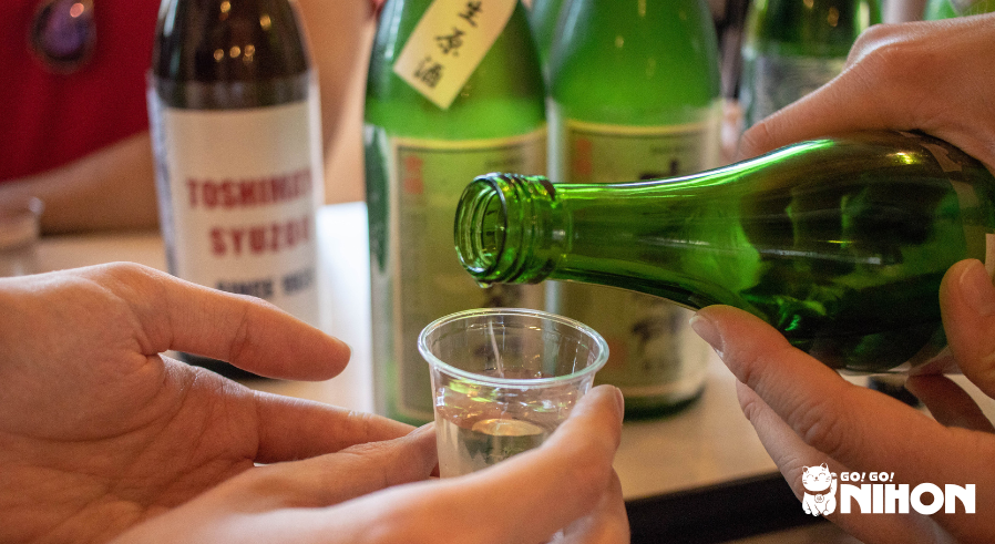 A person pouring someone else some sake