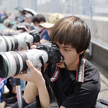 Adachi - school intro - student shooting a camera with telephoto lens