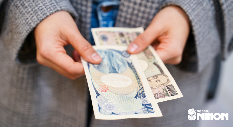 Person hält japanische Geldscheine in den Händen