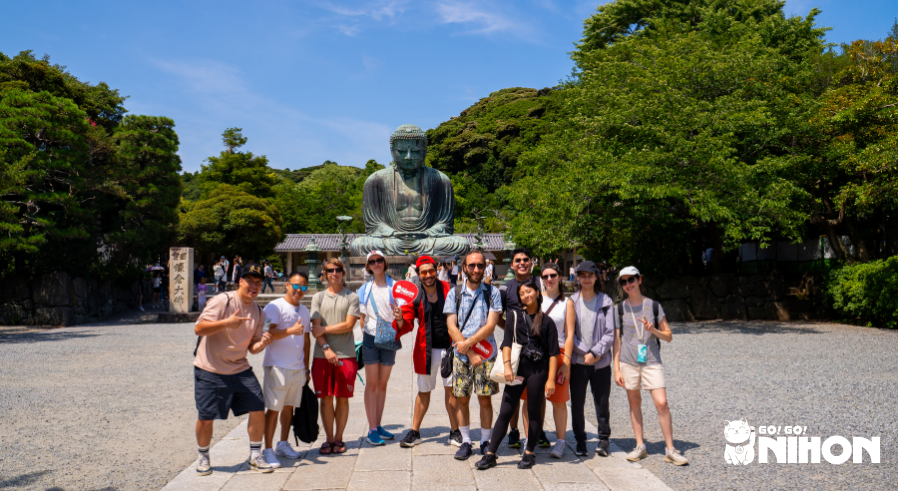 Group of students standing in front of Giant Buddha statue in Kamakura while on a study trip in Japan.