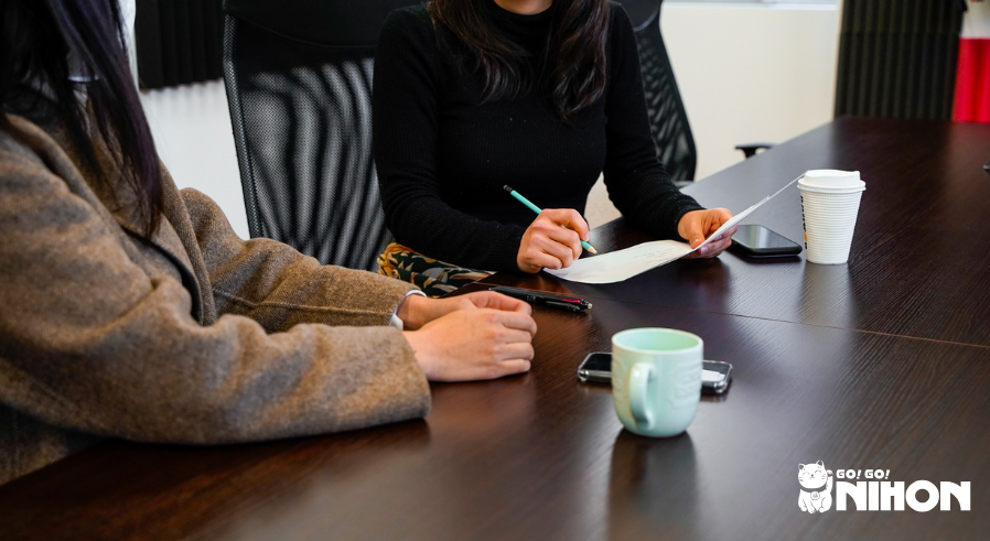 Zwei Personen, die an einem Schreibtisch in einem Büro sitzen und gemeinsam arbeiten