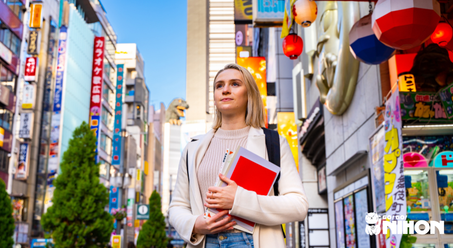 Bild på student med skolböcker i handen på gatorna i Shinjuku - alternativ för att studera i Japan