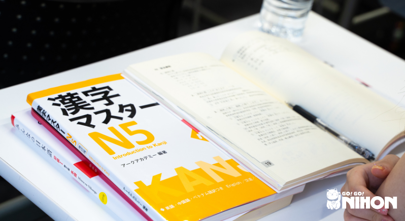 Photo d'un livre du JLPT N5 sur un bureau dans une salle de classe.