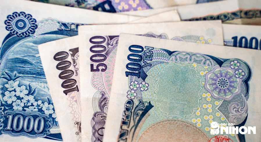 several yen bills stacked on top of each other