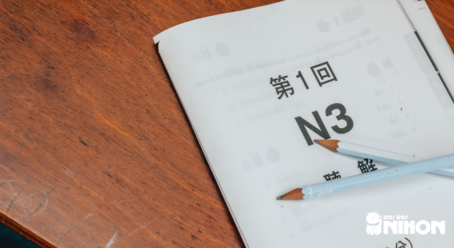 Guia de teste do JLPT N3 em uma mesa com dois lápis.