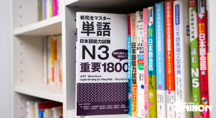 Livro didático do JLPT N3 retirado de uma prateleira.