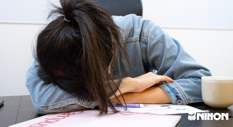 A person displaying one of the struggles foreign workers face in Japan: exhaustion and sleeping.