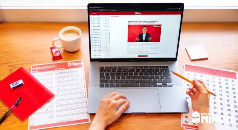 Open laptop and worksheets on a desk displaying a Go!Go! Nihon online Japanese language course and materials.