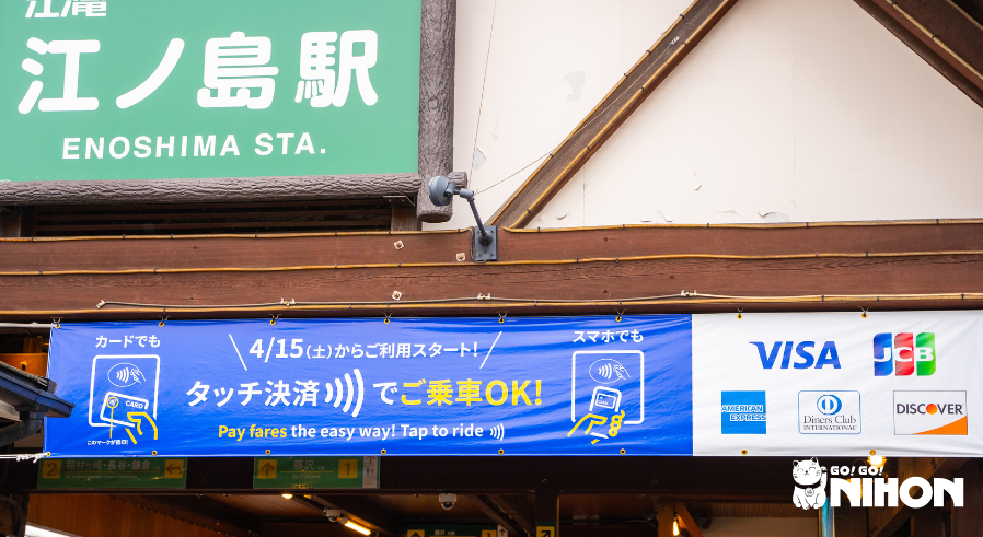 Entrance of Enoshima station with a credit card banner hanging.