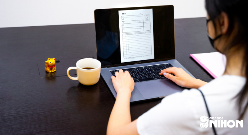 Persona di spalle che compila un CV per lavorare con la lingua giapponese