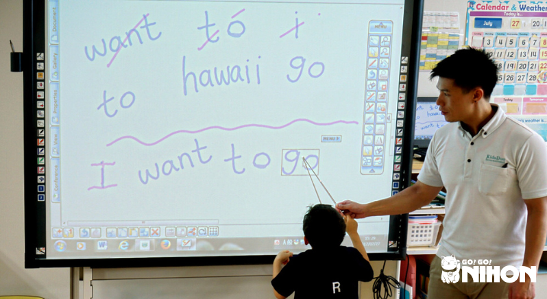 man teaching a child English in a classroom