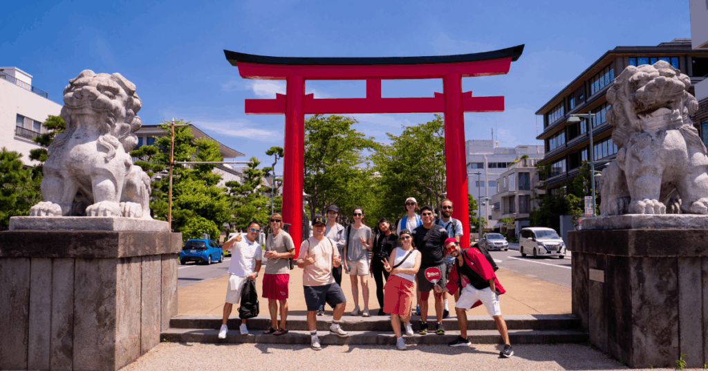 study trip group in front of red tori gate