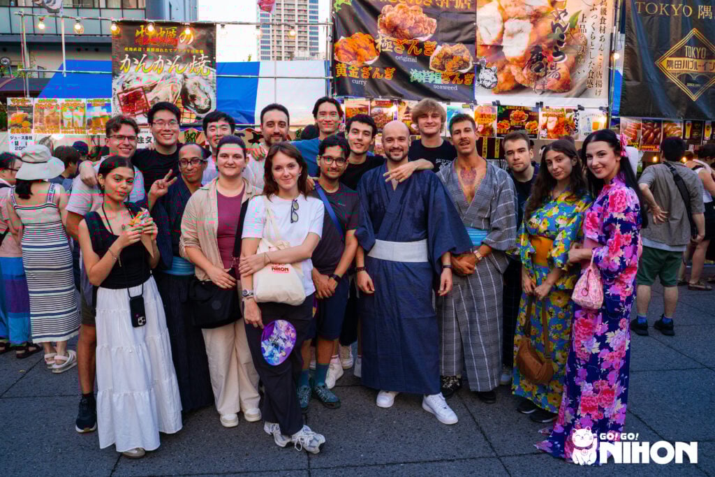 en grupp av studenter på studieresa till japan under en sommarfestival