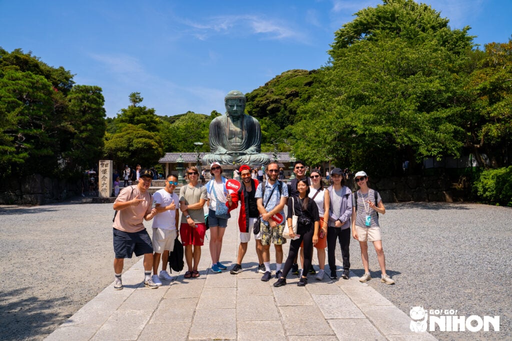 en grupp av studenter på studieresa framför den stora Buddhan i Kamakura