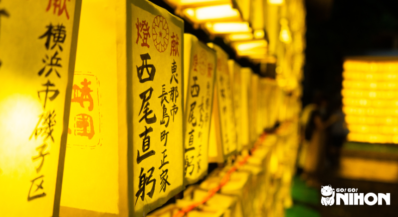 lit up paper lanterns glowing yellow with writing on them