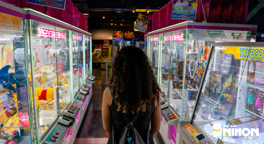 woman walking between UFO machines in an arcade in Japan