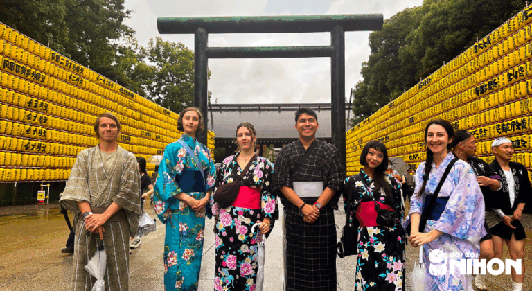 A group of young international students from a japan study tour smiling while wearing traditional Japanese kimono and yukata in a historic city setting.
