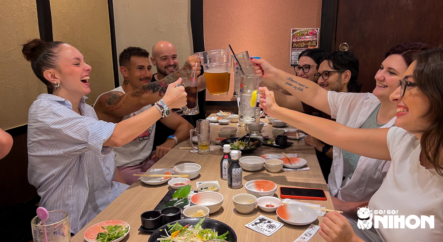 study trip group doing cheers at izakaya