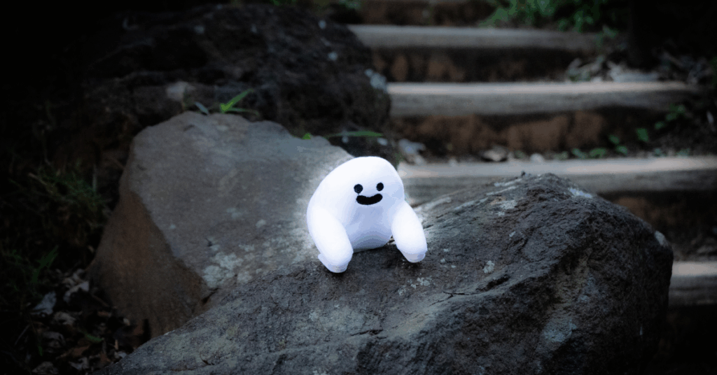 little white ghost sitting on a rock in toyama park