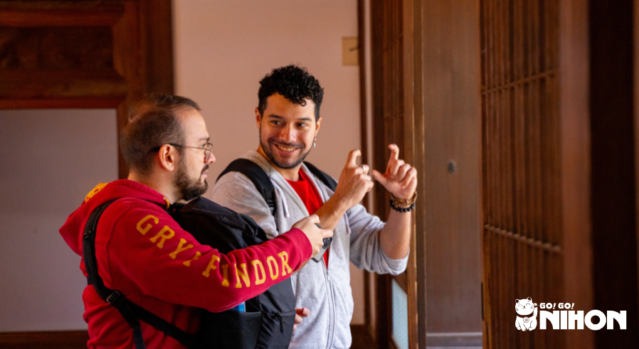 Tour Leader Jose speaking to a Study Tripper in wooden building