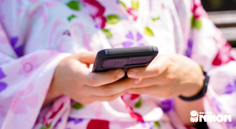 person in a kimono using their smartphone