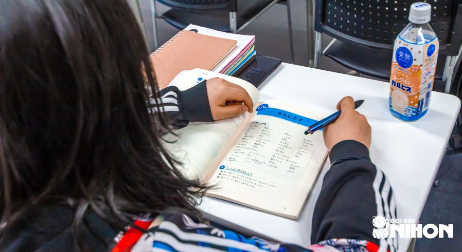 Student studying Japanese in a textbook.