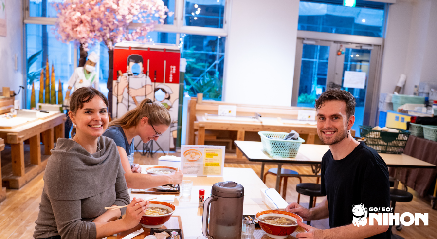 Three people eating ramen at a ramen restaurant