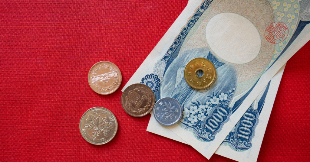 yen bills and coins on a red background