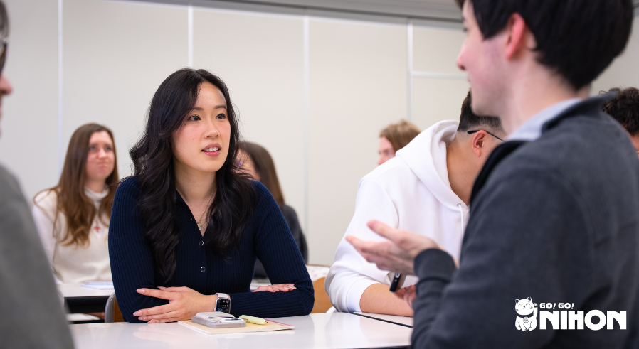 Two students discussing a lesson in a Japanese language school classroom