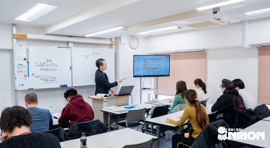 Teacher teaching a lesson to a class of students in a Japanese language school classroom