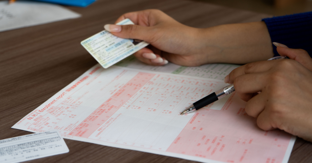 person filling out documents with zairyu card