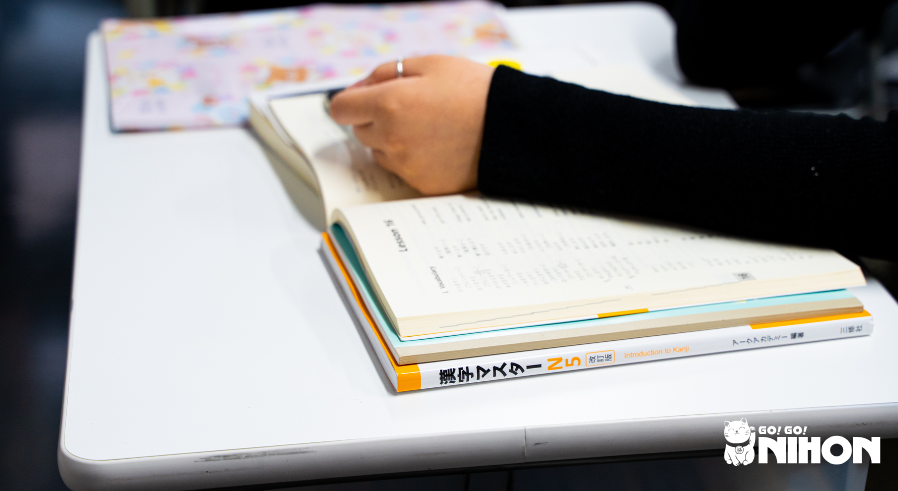 Uno studente che studia da un libro di testo e si prepara per l'esame JLPT