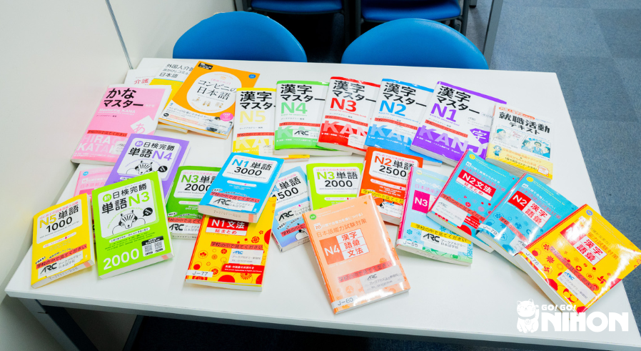 A pile of JLPT textbooks on a desk to study for a Japanese language test