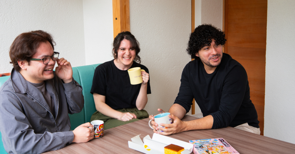 three spanish speaking people laughing at a table